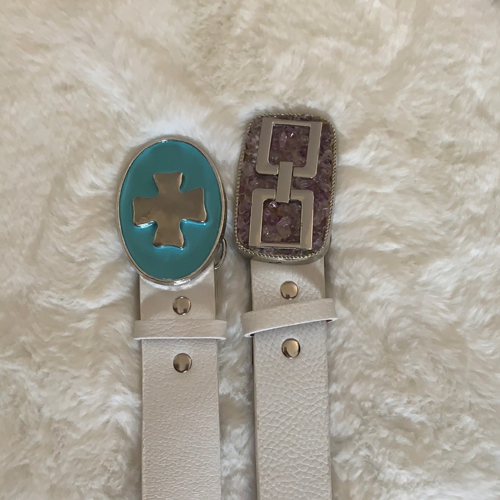 Two white belts with colorful buckles